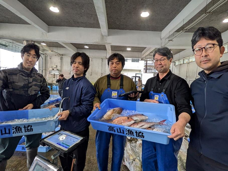 高山漁協の谷山浩貴参事（右から2人目）や木原徳彦管理課長（中央）は、ZIFISHの中村氏（右）の支援を受けて現場作業のデジタル化を進めている