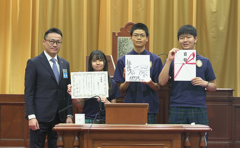 自由テーマ部門で会頭賞に選ばれた佐久長聖高校チームと、加藤会頭（左）