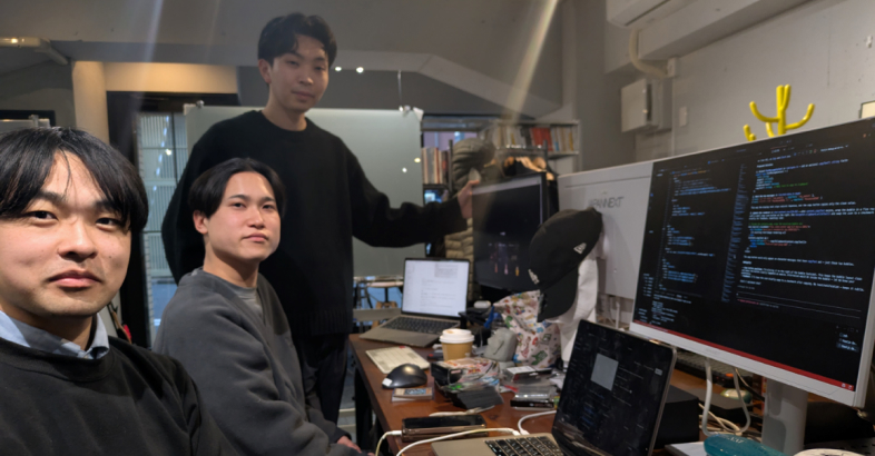 米国育ちの堀口氏（右）は最新AIを使ったプログラミングや多言語対応のプログラム開発などを担う。石川氏（中央）は総務省など政府や自治体の案件などを取りまとめている