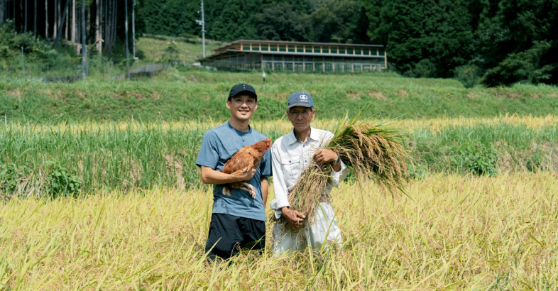 米作農家の高木氏（右）は知社集落で平飼いの卵の糞を使い、美味しい米作りに取り組んでいる