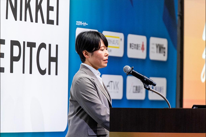 米田氏が舞台上でマイクに向かって話す様子