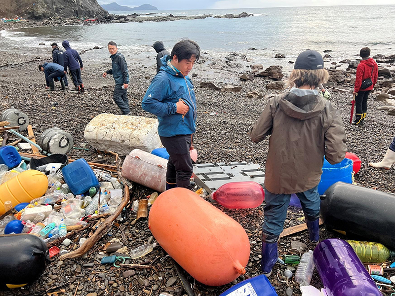 更家副社長（中央）は対馬で大量に漂着する海洋プラスチックごみの問題を視察し、問題解決に取り組んでいる。